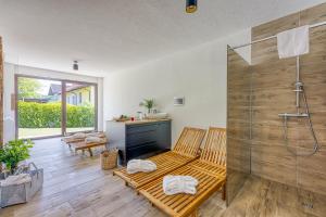 baño con banco de madera y ducha en VILA LISJAK - Apartments en Podčetrtek