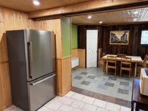 a kitchen with a stainless steel refrigerator and a table at l'appartement in Tadoussac
