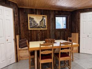 a dining room with a wooden table and chairs at l'appartement in Tadoussac