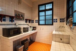 uma cozinha em azulejo com um micro-ondas no balcão em 文坊 Wen Guest House em Taipei