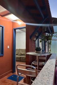 a kitchen with a table and chairs in a room at Quarto com Ar à 500m da praia Espaco Aconchego do Gugu in Arraial do Cabo +24 photos