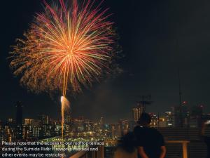 a firework exploding in the sky over a city at MIMARU Tokyo Asakusa Station in Tokyo