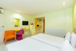 a bedroom with two beds and a desk with a computer at Bella Express in Pattaya Central