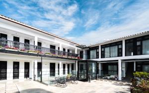 einen Blick nach außen auf ein weißes Gebäude mit einer Terrasse in der Unterkunft Lijiang Gemmer Hotel in Lijiang