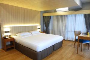 The Linden Suites في مانيلا: غرفة نوم بسرير كبير ومكتب