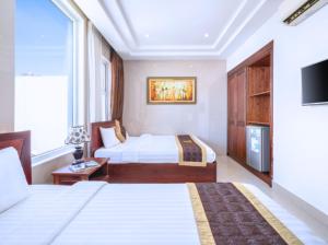 ダナンにあるDubai Hotelのベッド2台とテレビが備わるホテルルームです。