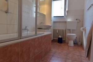 a bathroom with a tub and a toilet and a sink at HertenFlats - Rooms & Apartments - Kreis Recklinghausen in Herten +33 photos