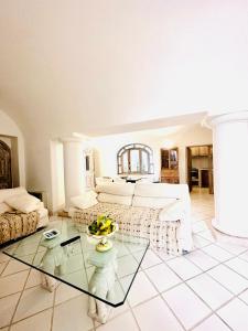 un soggiorno con divano e tavolo in vetro di I Tre Soli Apartments by CapriRooms a Capri