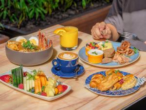 a table topped with plates of food and drinks at InterContinental Singapore Robertson Quay by IHG in Singapore +157 photos