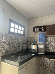 kuchnia z kuchenką i mikrofalówką w obiekcie Casa para temporada São João w mieście Campina Grande