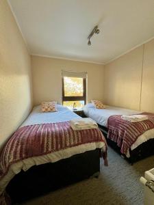 1 dormitorio con 2 camas y ventana en Departamento en Termas de Chillan, en Nevados de Chillán