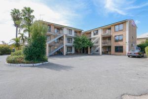 a large apartment building with a car parked in a parking lot at Apartment 8 Burswood in Perth