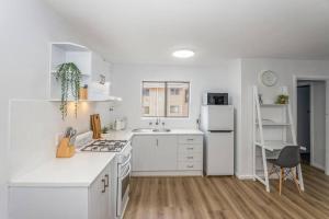 Una cocina blanca con fregadero y refrigerador. en Apartment 8 Burswood, en Perth 11 fotos más