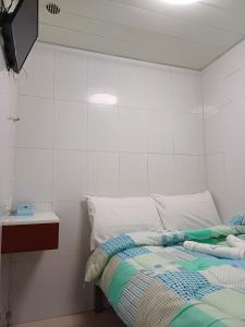 a bedroom with a bed and a tv on a wall at DREAMNEST GUESTHOUSE Tsim Sha Tsui in Hong Kong