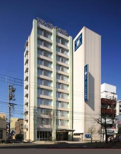 a large building with a sign on top of it at Smile Hotel Matsuyama in Matsuyama