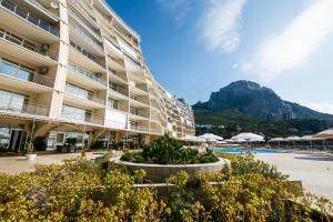 a large building with a pool and a mountain in the background at Hotel Complex Bukhta Mechty in Laspi