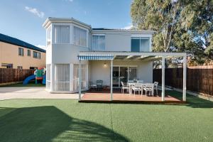 a house with a deck with a table and chairs at StayAU Family Group 6BR Oasis Sanctuary Lakeview in Point Cook