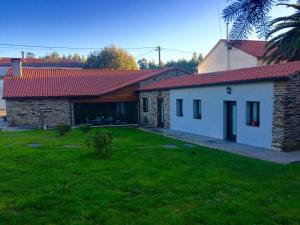 una casa con techo rojo y patio en Casa Garea, en Arzúa