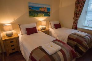 A bed or beds in a room at The Mill Inn Apartments 