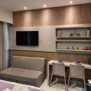 um quarto com um sofá, uma mesa e uma televisão em Mana Beach Experience Muro Alto 13 C Térreo em Porto de Galinhas