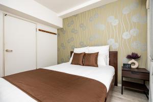 a bedroom with a bed and a flowery wallpaper at Bijou Suites Pine Brook 405 in Osaka