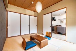 a living room with a wooden table and two chairs at Bijou Suites Pine Brook 405 in Osaka