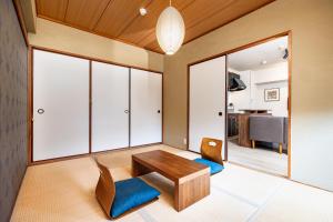 - un salon avec une table en bois et 2 chaises dans l'établissement Bijou Suites Pine Brook 405, à Osaka