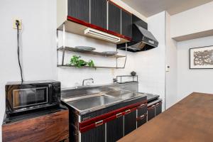 a kitchen with a sink and a microwave at Bijou Suites Pine Brook 405 in Osaka
