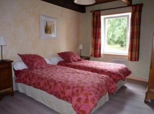 una camera d'albergo con due letti e una finestra di Gites de la Haie a Plouégat-Moysan