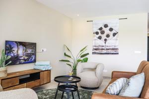 a living room with two chairs and a tv at Caribbean Vibes in Willemstad
