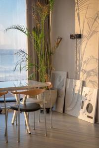 uma mesa e cadeiras numa sala com um vaso de plantas em Sosodang 최고층 오션뷰 복층 호텔 em Incheon