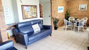 sala de estar con sofá azul y mesa en Joanne Apartments, en Caloundra