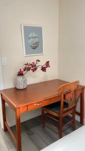 un bureau en bois avec un vase de fleurs dessus dans l'établissement #304 Mountain View 1BR in Canmore DT, à Canmore