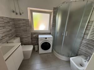 a bathroom with a shower and a washing machine at La Casa Blu in Mirabella Imbaccari