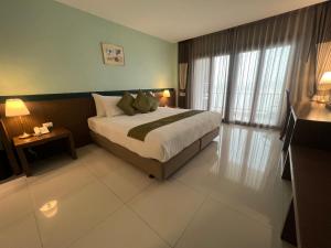 Un pat sau paturi într-o cameră la Siam Triangle Hotel