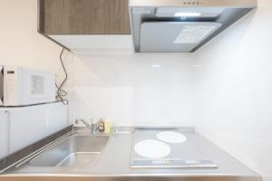 a kitchen with a sink and a microwave at MAT Nogata in Tokyo