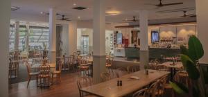 un restaurante con mesas y sillas y un bar en Plantation Hotel Coffs Harbour en Coffs Harbour
