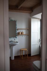 Un baño con un lavabo, un taburete y un espejo. en NAMOR-Estudio Galeria, en Ribadeo