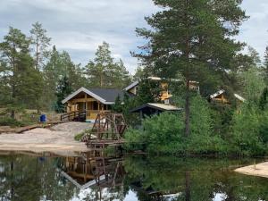 een huis naast een waterlichaam bij Luxury Holiday Home with Private Lake in Vehmaa