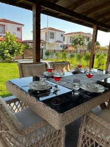 a table with glasses of red wine on it at Gökova Nergis Evleri in Milas