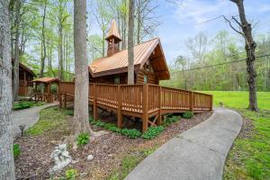 een grote houten hut in het bos met een loopbrug bij Parkway Treasure cabin in Gatlinburg