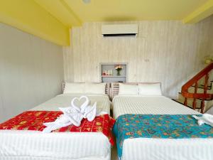a bedroom with two beds with bows on them at Santa's House in Xiaoliuqiu