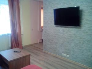 een woonkamer met een flatscreen-tv op een bakstenen muur bij Apartment Syrec in Kiev