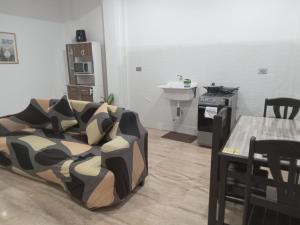 a living room with a bed and a table with chairs at Mini Hostal Cardos in Pisco
