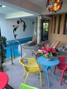 a patio with colorful chairs and a table with a vase of flowers at Hotel Livin in Tbilisi City