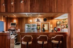 un bar con taburetes marrones en un restaurante en Riverfront Motel & Villas, en Hobart