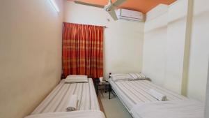 3 camas en una habitación con cortina roja en Hotel The Sylhet International, en Dhaka