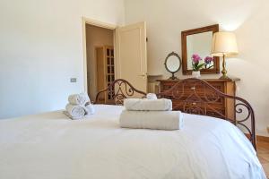 ein Schlafzimmer mit einem weißen Bett und Handtüchern darauf in der Unterkunft Seconda fila mare by WeHostYou aria condizionata parcheggio in Lido di Fermo