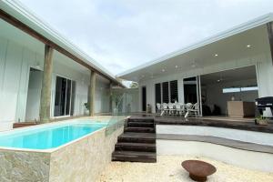 a home with a swimming pool and a house at Casa Tropico - Mission Beach in Mission Beach