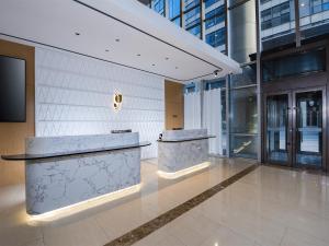 a lobby with two counters in a building at Country Inn & Suite by Radisson, Tianjin Wuqing Development Zone Wanda Plaza in Wuqing